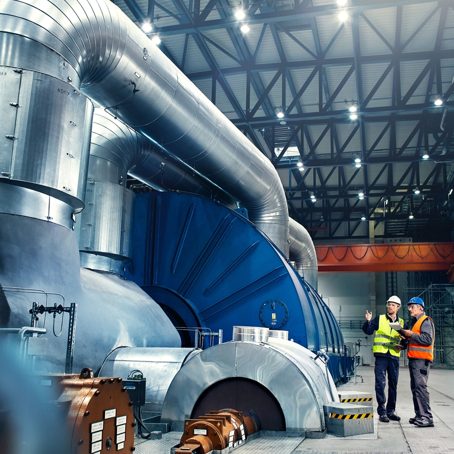 Primer plano de un ingeniero frente a una turbina de una central eléctrica