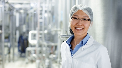 Una mujer de pie en una planta de procesamiento de leche
