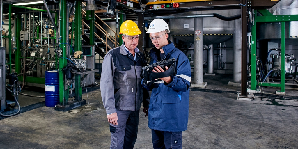 Empleado de Endress+Hauser con un cliente en la planta agroquímica utilizando el Field Xpert