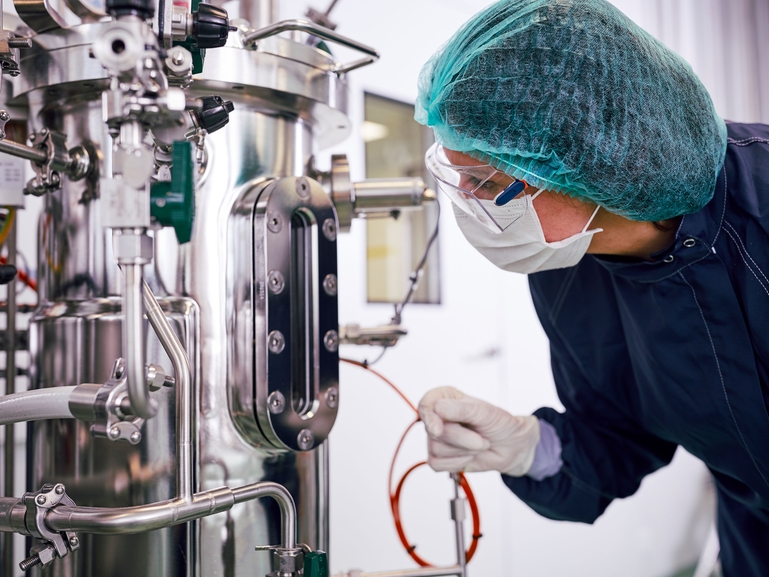Personal científico con un fermentador para la producción biofarmacéutica en la industria de las Ciencias de la Vida Fermentador y personal científico en fabricación biofarmacéutica